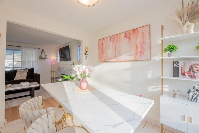 dining area featuring light tile patterned floors and a fireplace