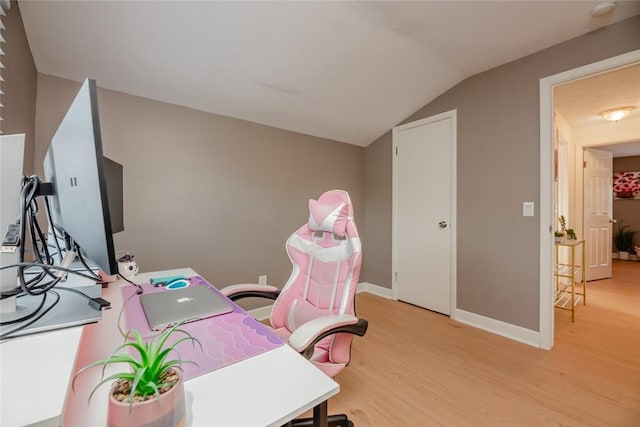 home office with lofted ceiling, light wood-style floors, and baseboards