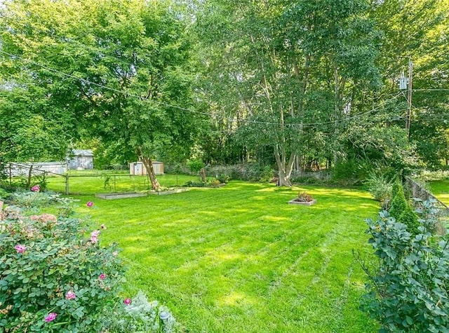 view of yard featuring fence and an outdoor fire pit