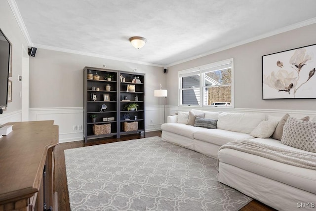 living room featuring a wainscoted wall, crown molding, and wood finished floors