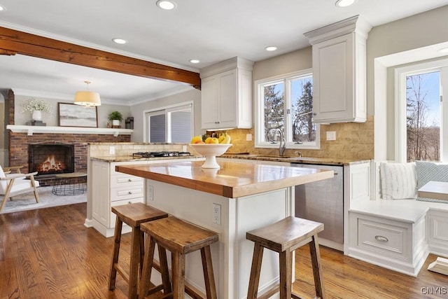 kitchen featuring wood finished floors, a peninsula, stainless steel appliances, and a sink