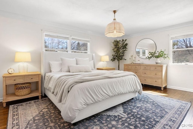 bedroom featuring wood finished floors, baseboards, and ornamental molding