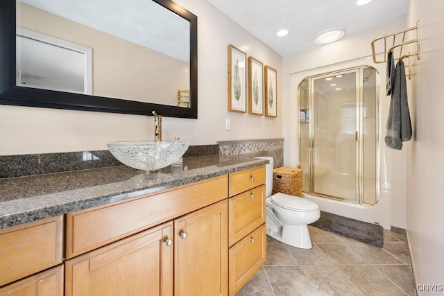 bathroom featuring tile patterned floors, toilet, a stall shower, recessed lighting, and vanity