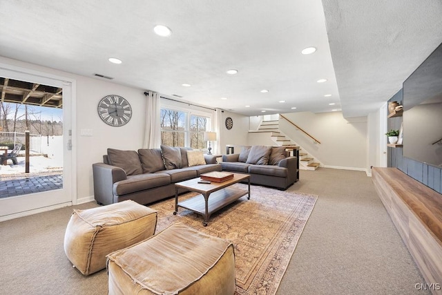 living area featuring stairs, plenty of natural light, light colored carpet, and visible vents