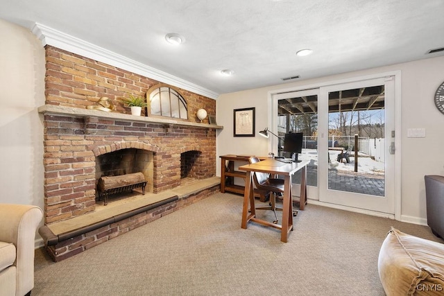 carpeted home office featuring crown molding, a fireplace, baseboards, and visible vents