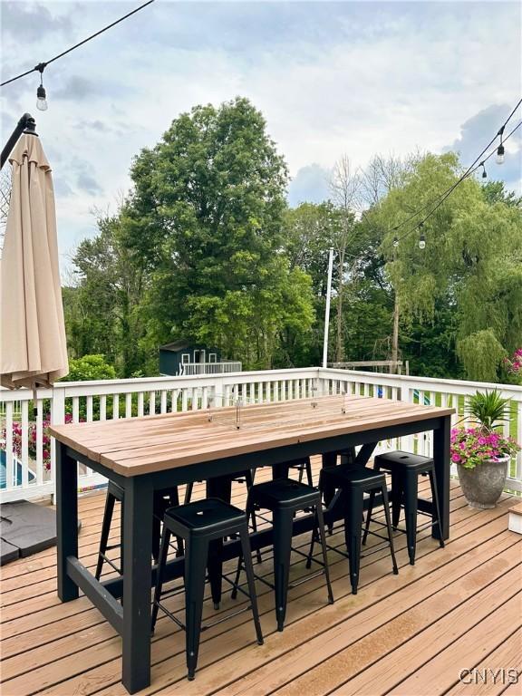 deck featuring outdoor dining space, an outbuilding, and a storage unit