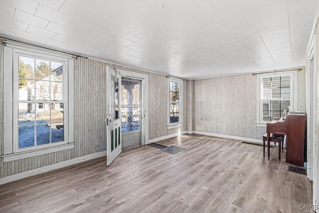 entrance foyer with a wealth of natural light, visible vents, baseboards, and wood finished floors