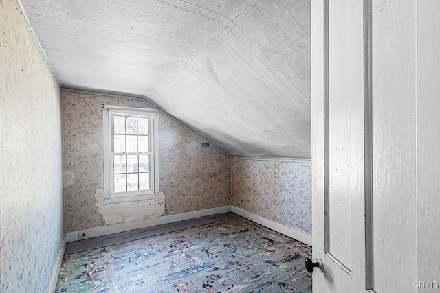 bonus room featuring baseboards, lofted ceiling, and wallpapered walls