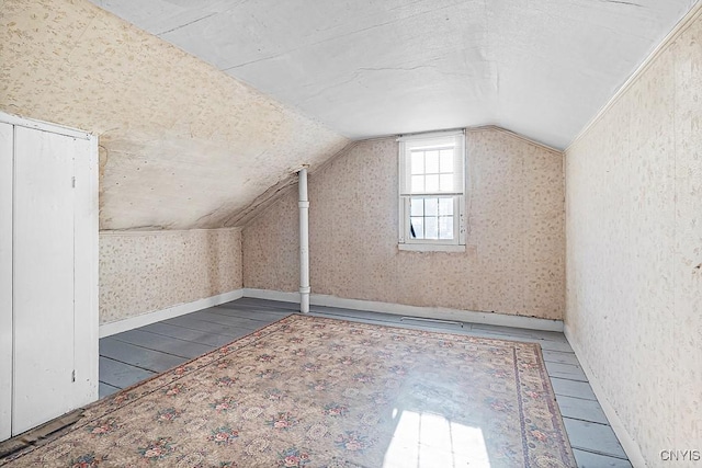 additional living space featuring hardwood / wood-style floors and vaulted ceiling