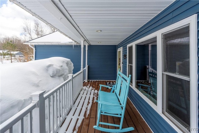 view of snow covered back of property