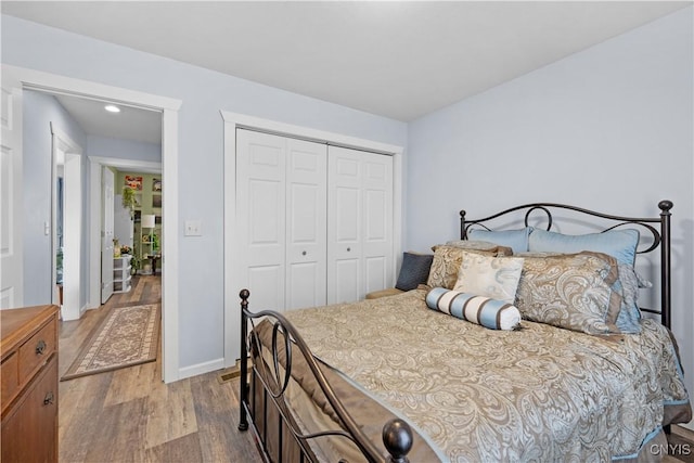 bedroom featuring a closet, baseboards, and wood finished floors