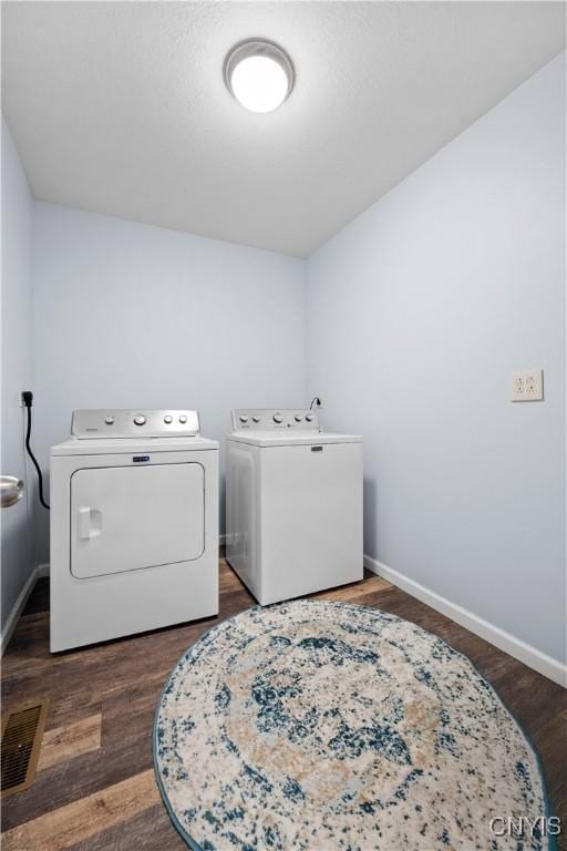 washroom featuring baseboards, wood finished floors, laundry area, and washer and clothes dryer