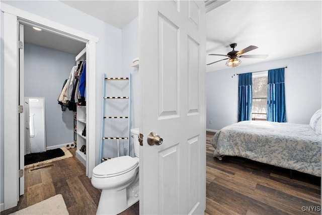 bedroom with baseboards, dark wood-style flooring, a closet, and ceiling fan