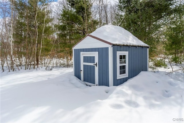 snow covered structure with an outdoor structure and a storage unit