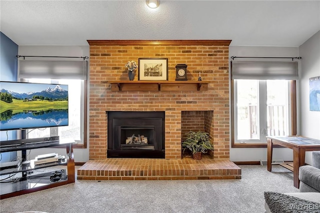 living area featuring visible vents, a brick fireplace, carpet flooring, and a healthy amount of sunlight