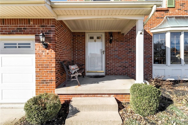 doorway to property with brick siding and an attached garage