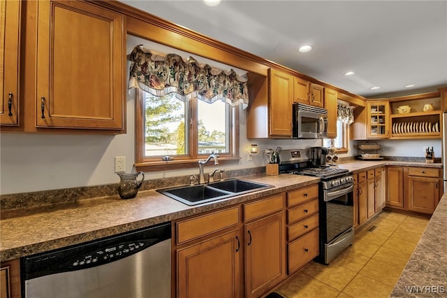 kitchen featuring a sink, light tile patterned floors, a wealth of natural light, and stainless steel appliances