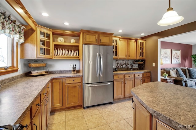 kitchen with glass insert cabinets, recessed lighting, brown cabinets, and freestanding refrigerator