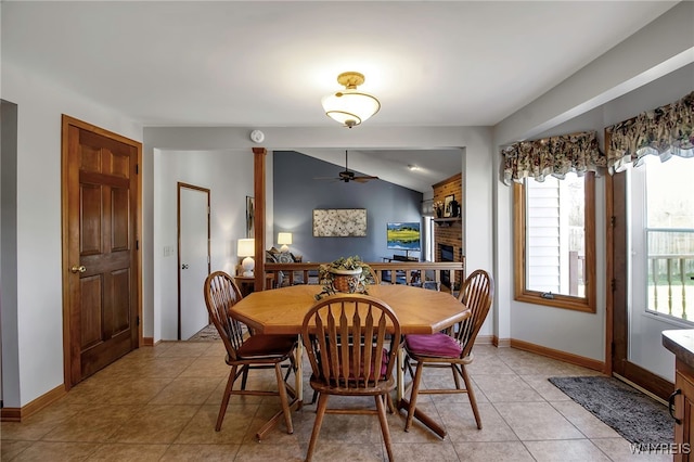 dining space with light tile patterned flooring, ceiling fan, baseboards, and lofted ceiling