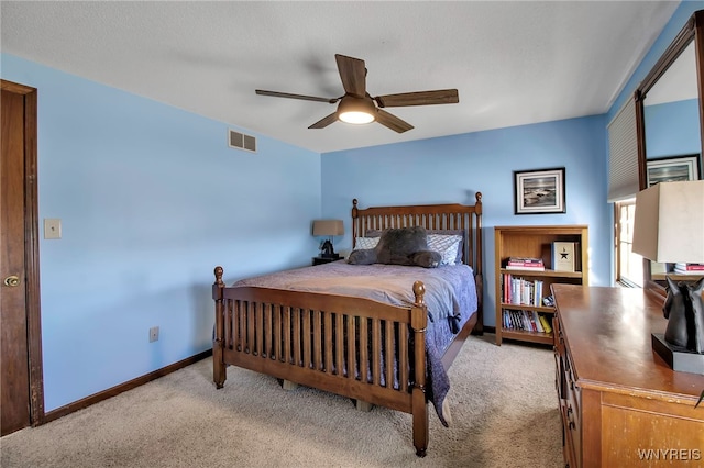 carpeted bedroom with visible vents, baseboards, and ceiling fan