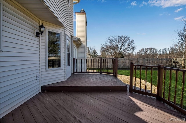 wooden terrace with a yard and fence