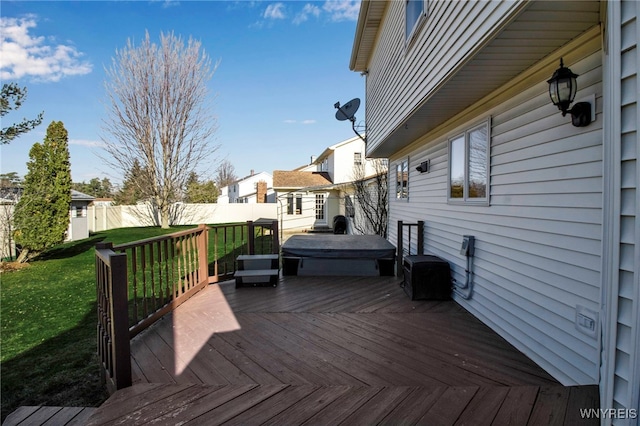 wooden terrace with a lawn, a covered hot tub, and fence