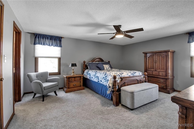 carpeted bedroom featuring a ceiling fan, baseboards, and a textured ceiling