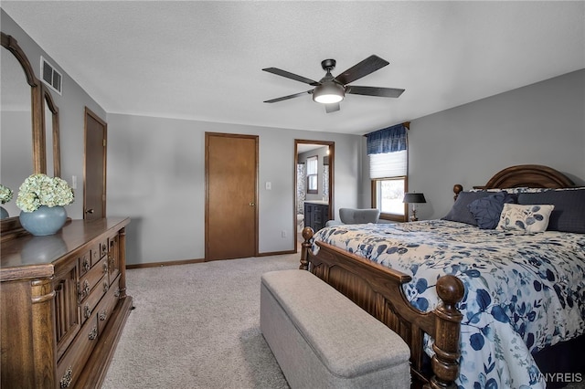 bedroom featuring visible vents, light colored carpet, a textured ceiling, and baseboards