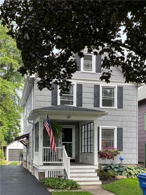 american foursquare style home featuring an outbuilding and a porch