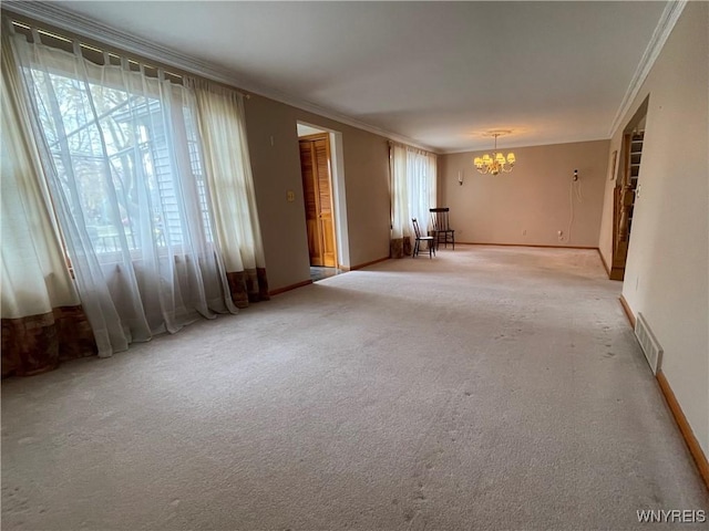 spare room featuring a chandelier, visible vents, plenty of natural light, and ornamental molding