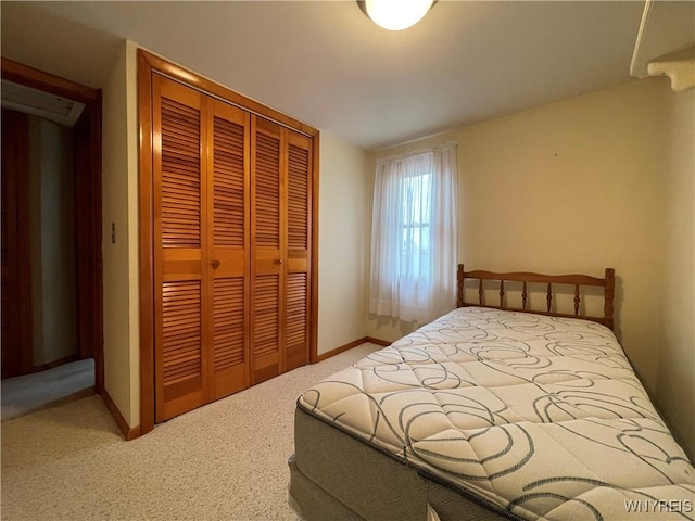 carpeted bedroom featuring baseboards and a closet