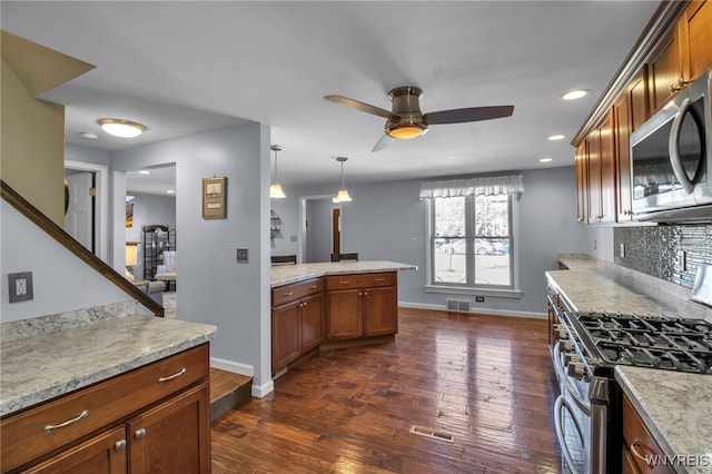 kitchen featuring a ceiling fan, visible vents, dark wood-style flooring, stainless steel appliances, and backsplash