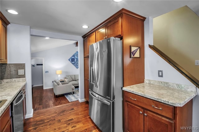 kitchen featuring stainless steel appliances, tasteful backsplash, dark wood-type flooring, and light countertops