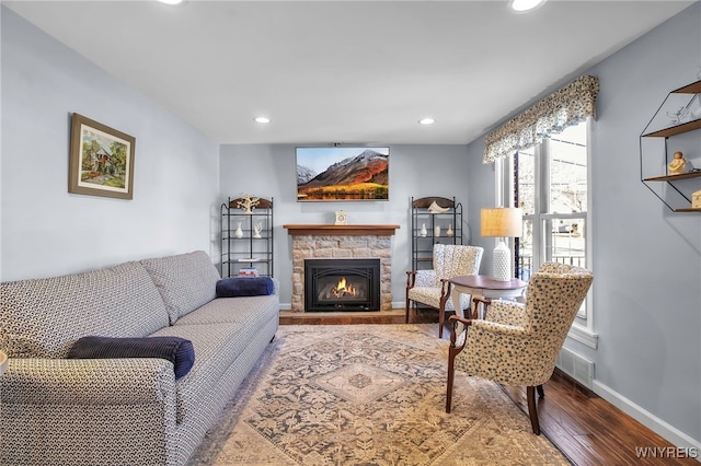 living room with a fireplace, recessed lighting, wood finished floors, and baseboards