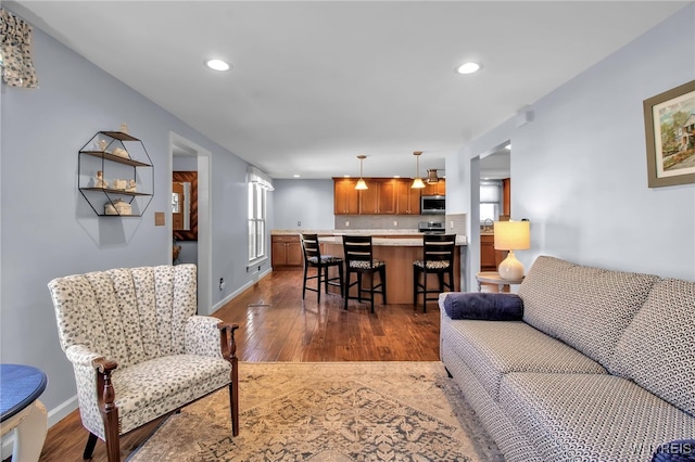 living room with dark wood-style floors, recessed lighting, and baseboards