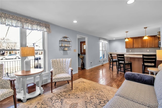 living area with recessed lighting, visible vents, baseboards, and wood finished floors