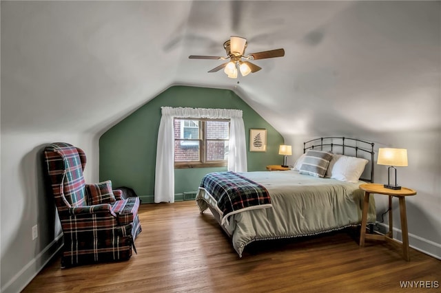 bedroom with baseboards, lofted ceiling, wood finished floors, and a ceiling fan