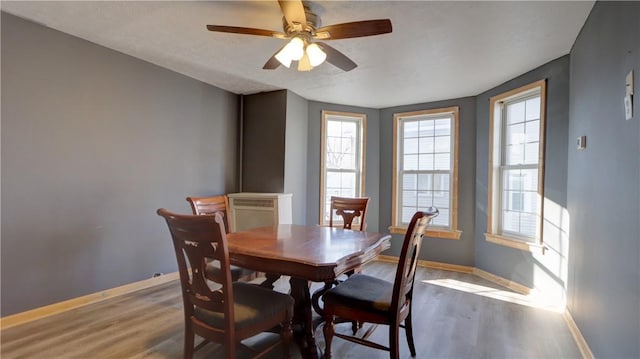 dining area with wood finished floors, baseboards, and ceiling fan