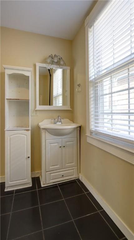 bathroom featuring vanity, tile patterned floors, baseboards, and a wealth of natural light