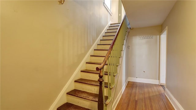 staircase with baseboards and wood finished floors