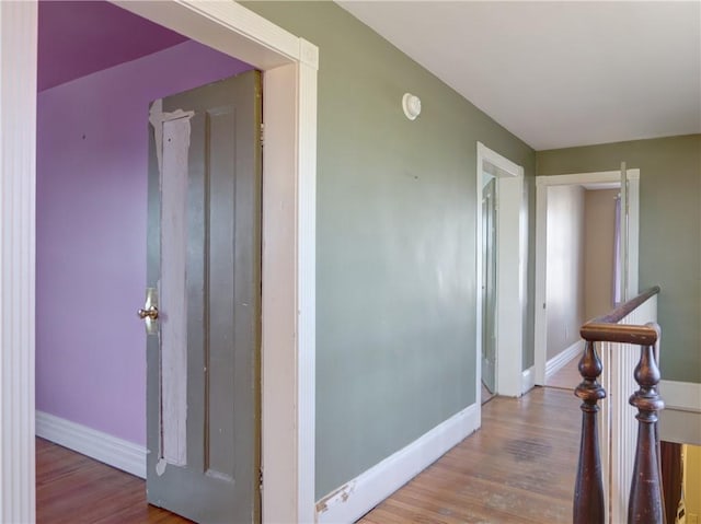 corridor featuring baseboards and wood finished floors