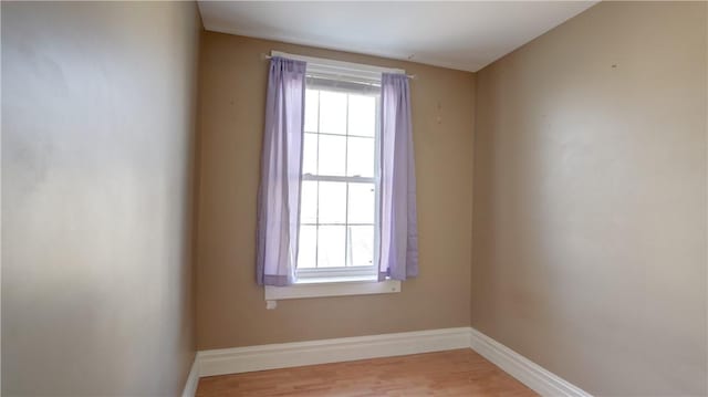 empty room featuring baseboards, plenty of natural light, and wood finished floors