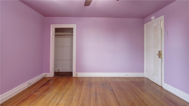 unfurnished bedroom featuring ceiling fan, a closet, baseboards, and light wood-style flooring