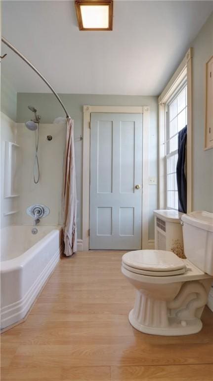 bathroom with toilet, wood finished floors, and shower / bath combo