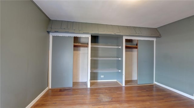 unfurnished bedroom featuring a closet, baseboards, and wood finished floors