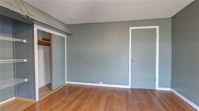 unfurnished bedroom with a closet, baseboards, and wood finished floors