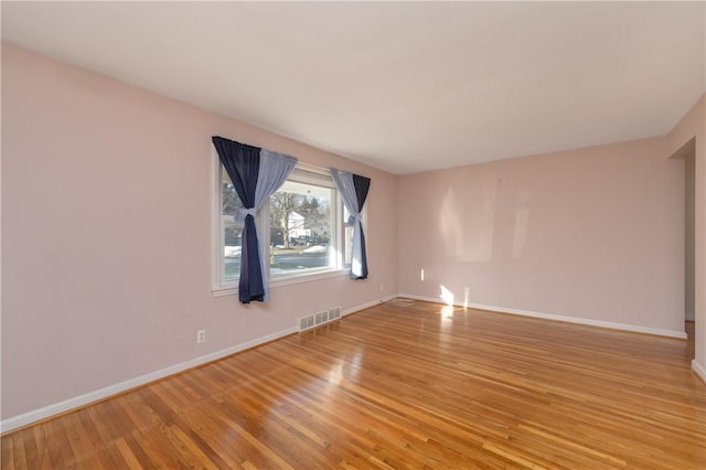 unfurnished room featuring baseboards, visible vents, and light wood-type flooring