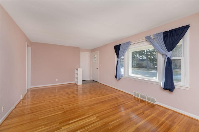 unfurnished living room featuring light wood-type flooring, visible vents, and baseboards