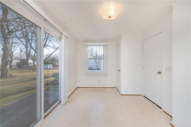 spare room featuring baseboards and light floors