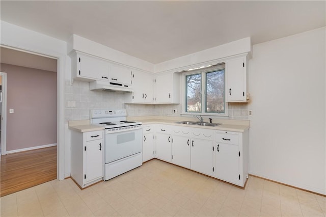 kitchen featuring a sink, under cabinet range hood, white electric range oven, and light countertops